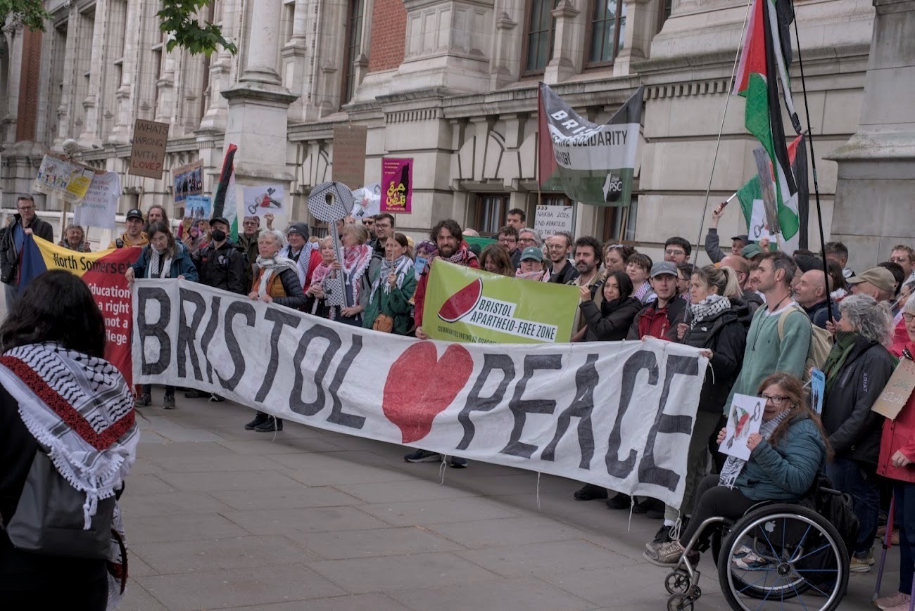 A group of people hold a large banner that says Bristol loves peace